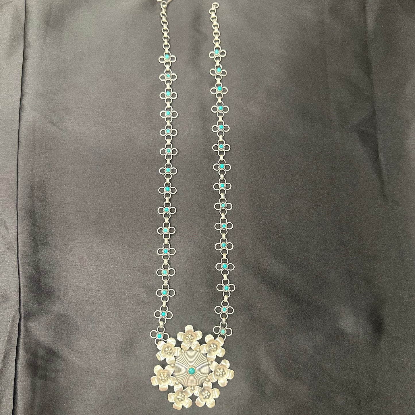 NEELU. Stunning turquoise studded necklace in pure silver with a  floral centrepiece .